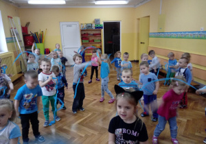 Dzieci improwizują do muzyki, wykorzystując niebieskie wstążki